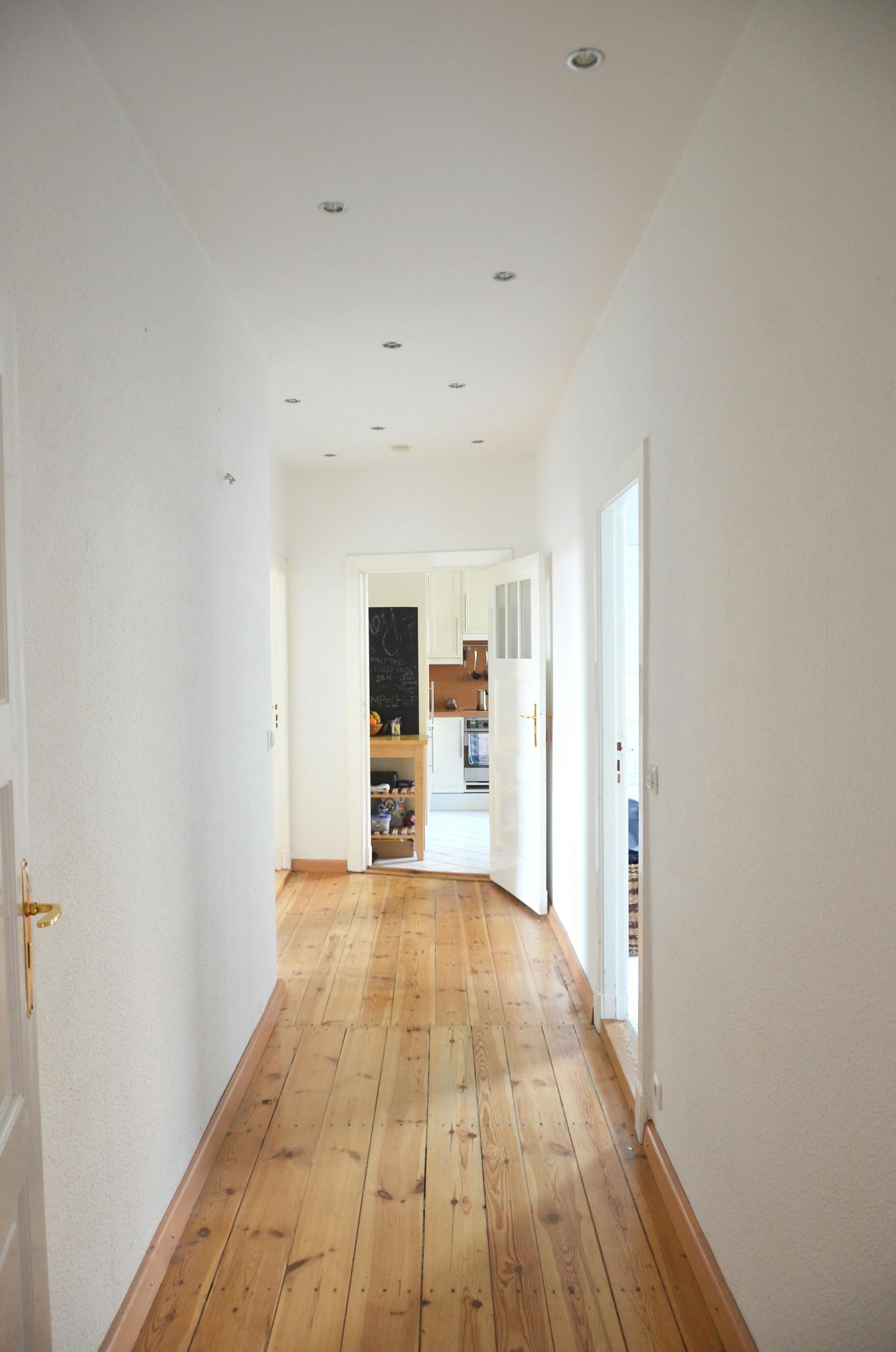 Bright hallway in a modern apartment featuring wooden floors and minimalist design.